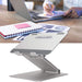 Ergonomic silver laptop stand holding a laptop, perfect for any workspace, available at TaMiMi Projects in Qatar.